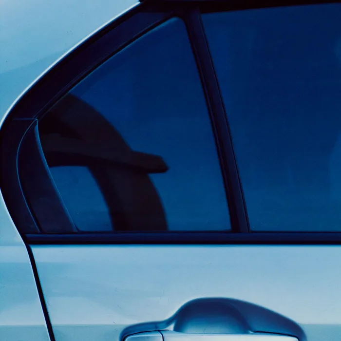 Close-up of a freshly tinted car window showing clean ceramic film edge